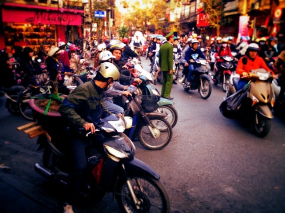 An official looking man stands amidst the chaos, presumably after having given up trying to direct it.